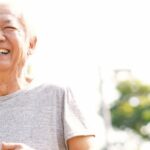 An elderly Asian couple jogging together in sunny weather