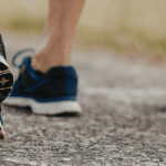 Image of two people's feet walking in sneakers